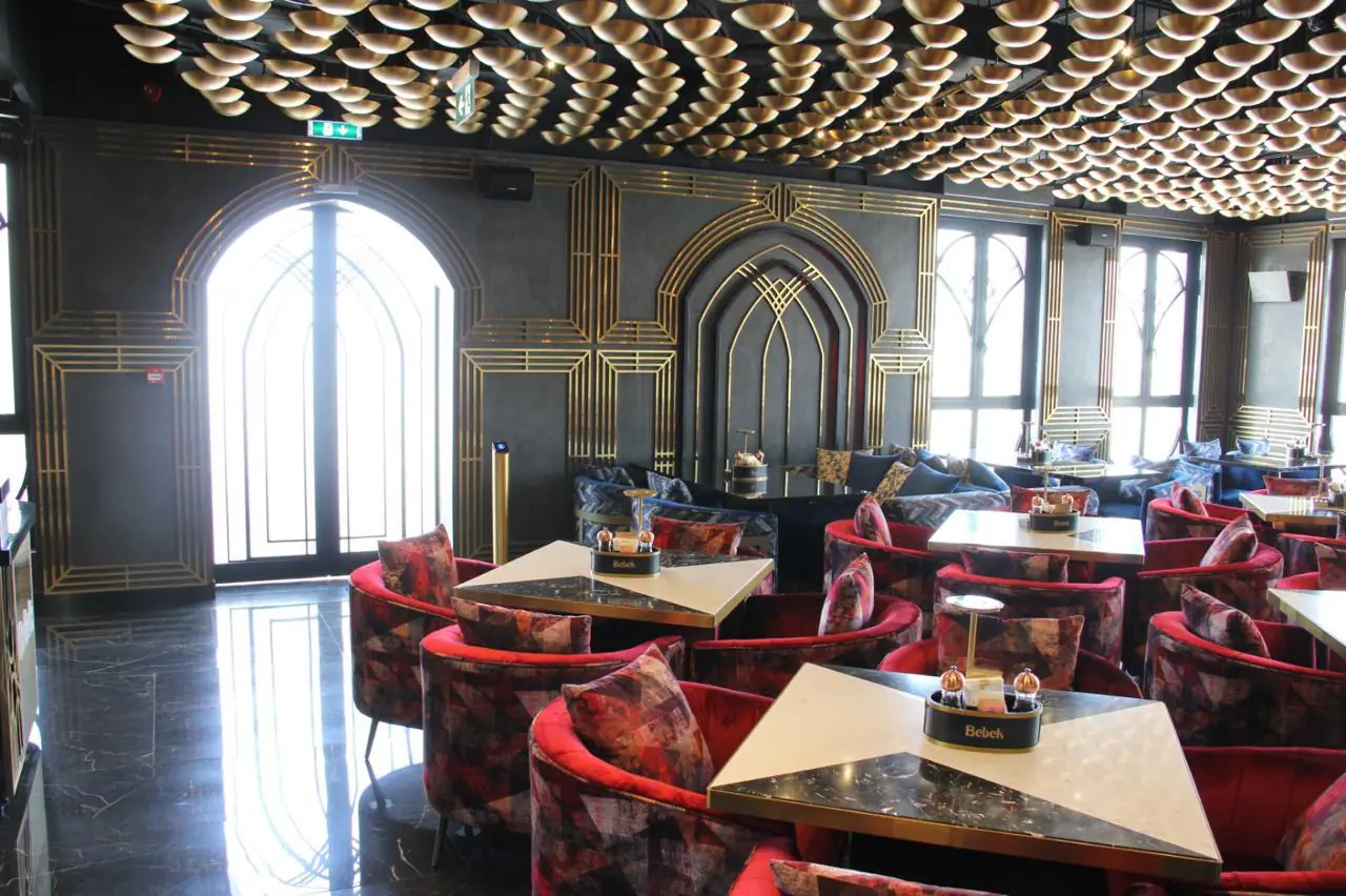 Bebek dining room with gold screens and red velvet chairs in Jumeirah