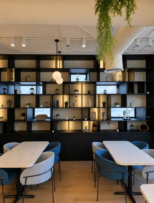 Black joinery wall with lit display shelves at Juan Valdez