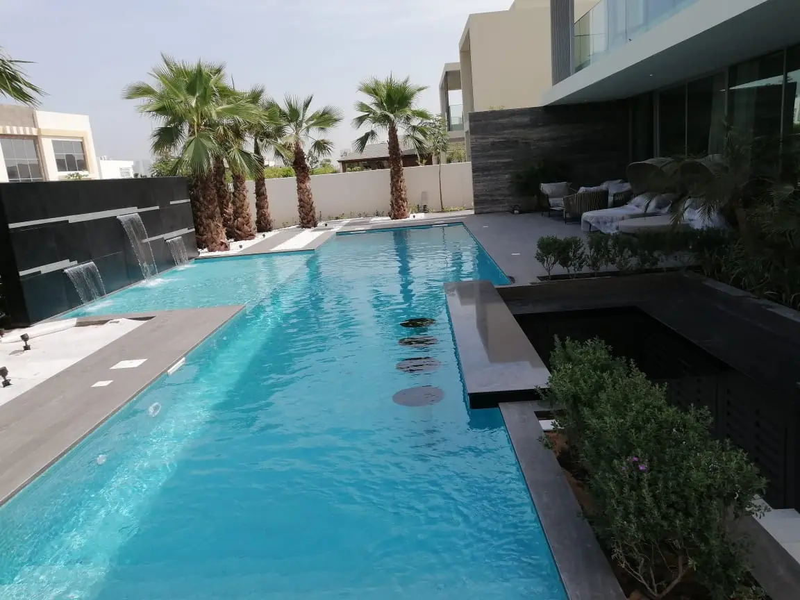 Private villa pool with a sunken bar and stone planters in Dubai